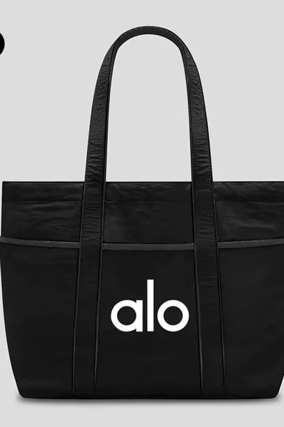 A black canvas tote with short handles and a small white logo, photographed flat