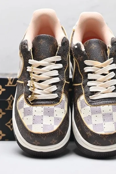 A pair of brown monogram-panelled trainers with cream laces, photographed from above